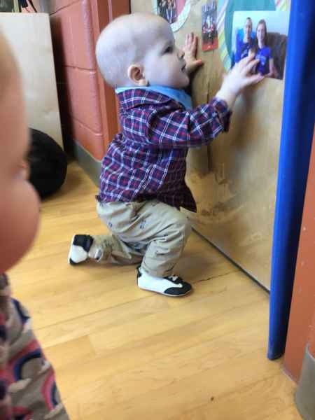 infant looking at a photo of his family